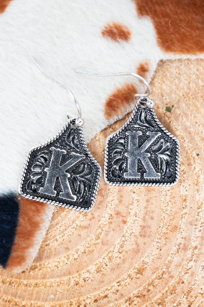 TIPI Cattle Tag 'K' Silvertone Earrings - Wholesale Accessory Market